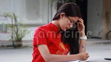 泰国少年漂亮女孩穿着中国服装写了一本书。